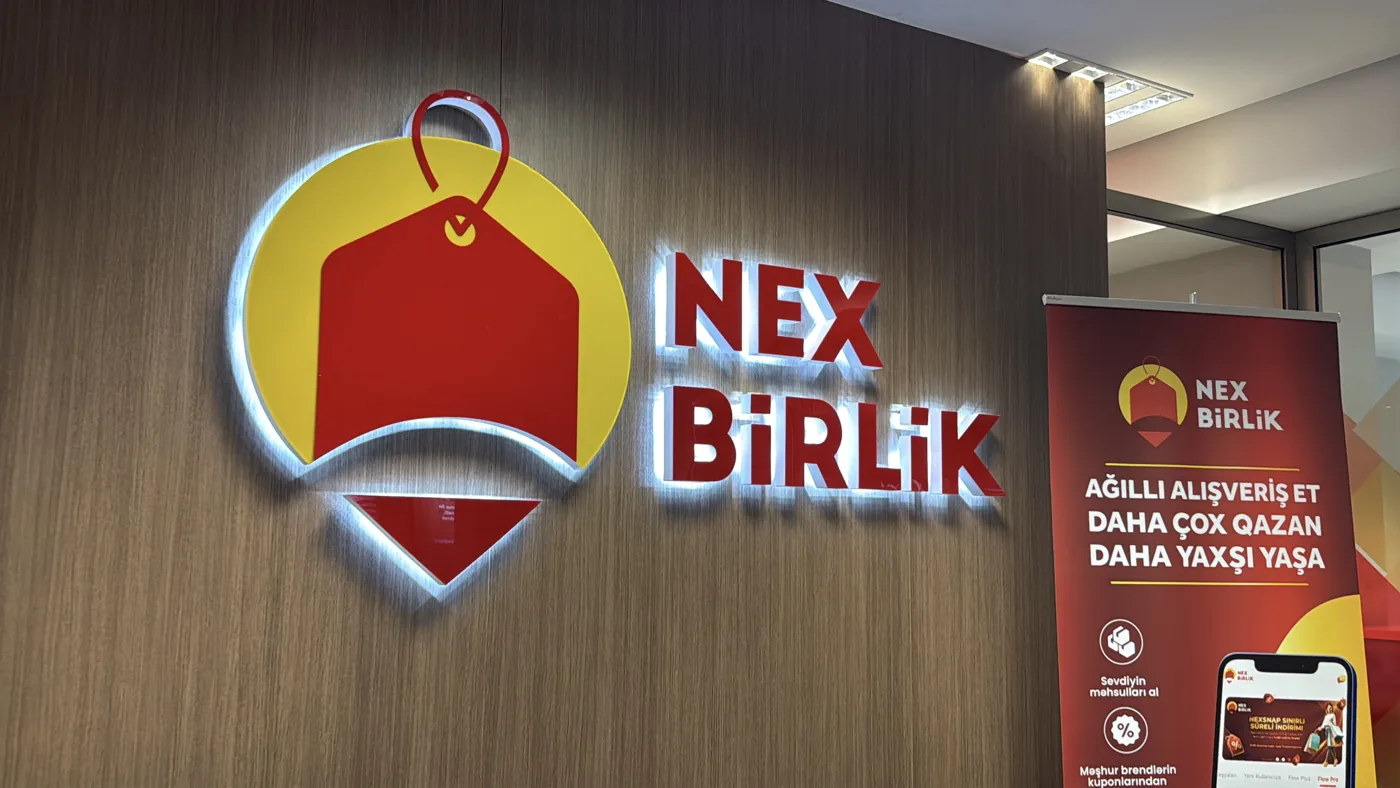 Divardakı brend nişanı və yanında təqdimat lövhəsi · müştərinin təqdim etdiyi foto